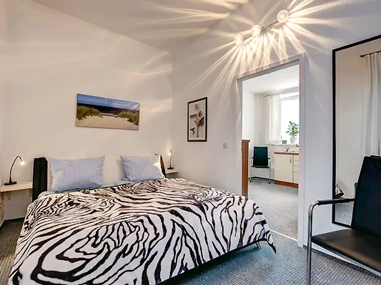 Schlafzimmer der Achternstube mit Doppelbett und Blick in den zweiten Raum