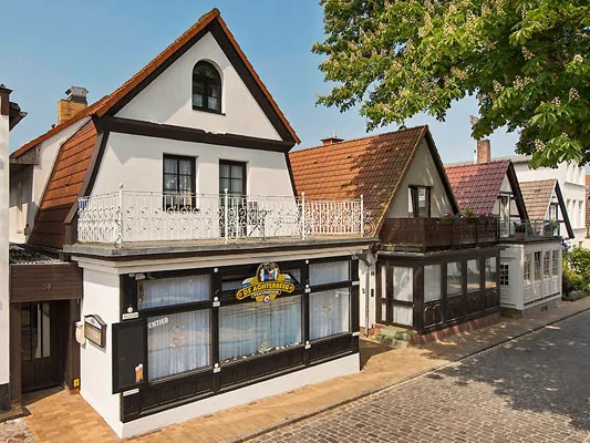 Haus mit den Ferienwohnungen in Warnemünde mit Giebeln, roten Dächern und Balkon