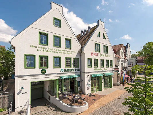 Außenansicht vom Hotel Zum Kater: weißes Giebelhaus mit grünen Fenstern und Katers Pub