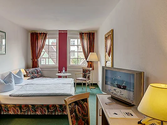 Doppelzimmer mit Doppelbett, Sitzecke und Blick auf die Giebelhäuser gegenüber