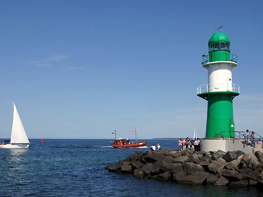 Grün-weißes Molenfeuer an der Westmole mit Segelboot auf der Ostsee
