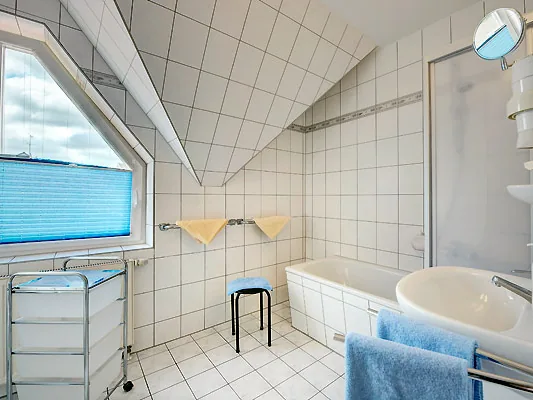 Badezimmer unter der Dachschräge mit Badewanne, Dusche und Fenster